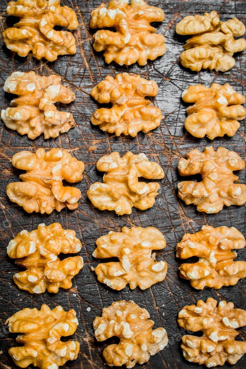 Preview: Peeled walnut on wooden background.