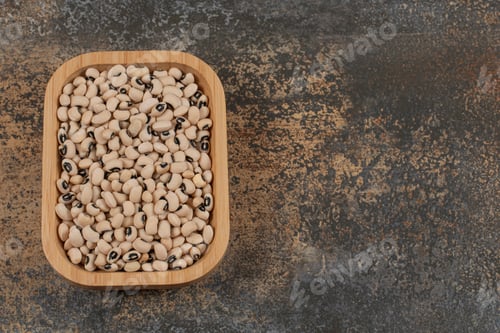 Preview: Pile of dry white beans on wooden plate