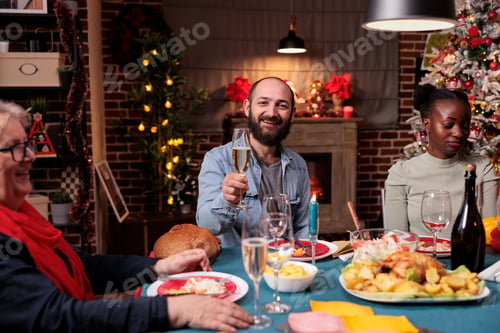 Preview: Family christmas celebration, friends drinking at festive dinner table