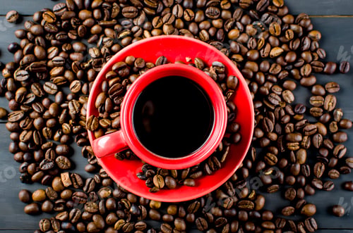 Preview: Black Coffee in red Ceramic cup and saucer and scattered coffee grains on dark wooden background.
