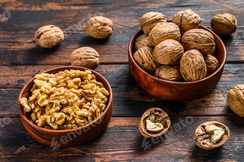 Preview: Shelled walnuts on wooden table. Dark background. Top view