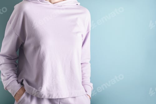 Preview: Cropped view of young adult woman wearing or dressed in stylish lilac sweatshirt and putting her ha