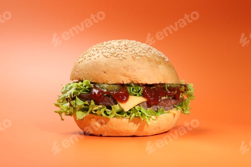 Preview: Delicious cheeseburger with lettuce, pickle, ketchup and patty on coral background, closeup