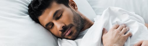 Preview: panoramic shot of handsome bi-racial man sleeping in bed in morning