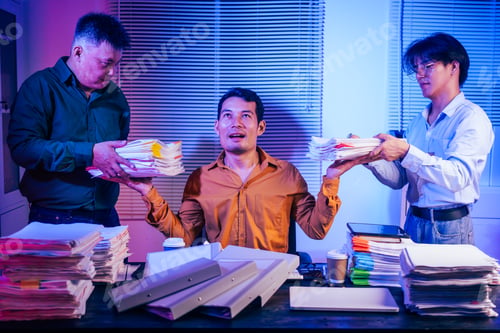 Preview: Three young businessmen work together on laptops in the office at night. They are stressed tired