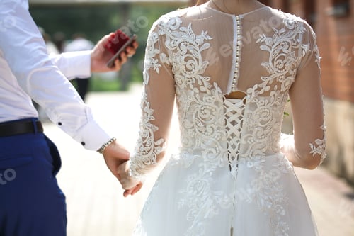 Preview: The back of the bride in a wedding dress with lace