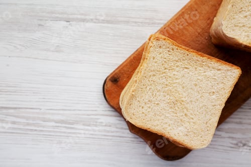 Preview: Slices of White Bread on a Rustic Wooden Board, top view. Flat lay, overhead, from above.