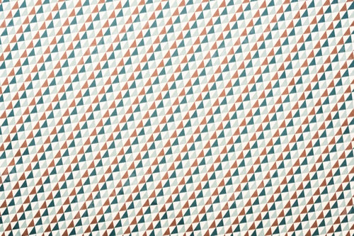 Preview: full frame of white fabric with green and brown triangles ornament background