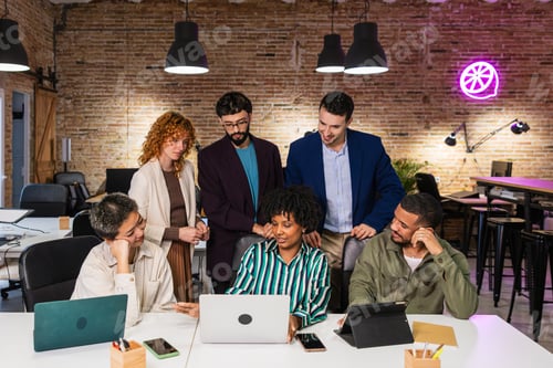 Preview: Multi ethnic team collaborating on project using laptop in modern office