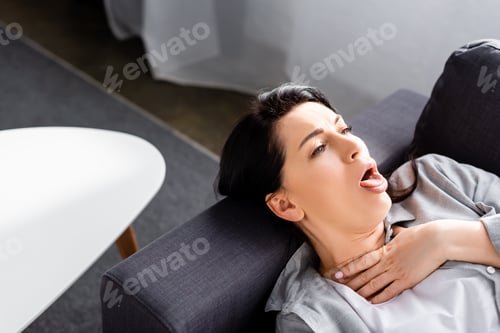Preview: sick woman coughing while lying on sofa