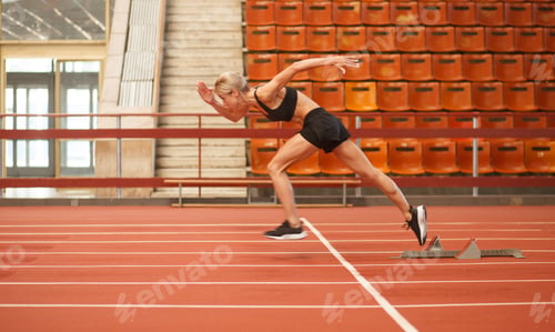 Preview: young blonde beautiful sportswoman training on athletic stadium