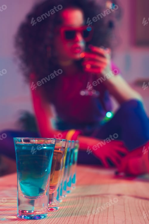 Preview: selective focus of alcohol shots on wooden counter in bar