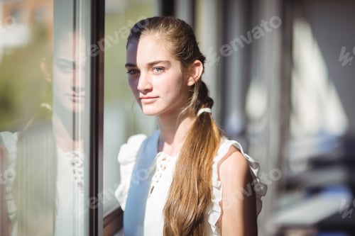 Preview: Portrait of schoolgirl standing near window in classroom