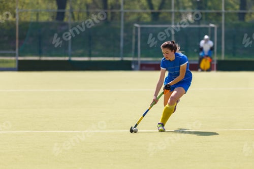 Preview: Young field hockey female player leading the ball in attack during the game