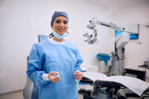 Preview: Happy female ophthalmologist working at eye clinic and looking at camera.
