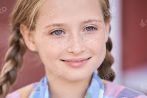 Preview: Smiling caucasian young girl with braided hair and freckles in casual attire