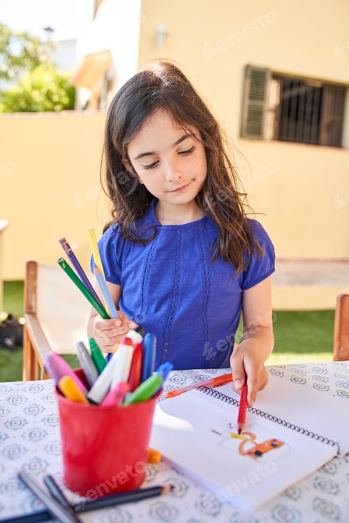 Preview: Preteen Hispanic girl coloring picture on paper