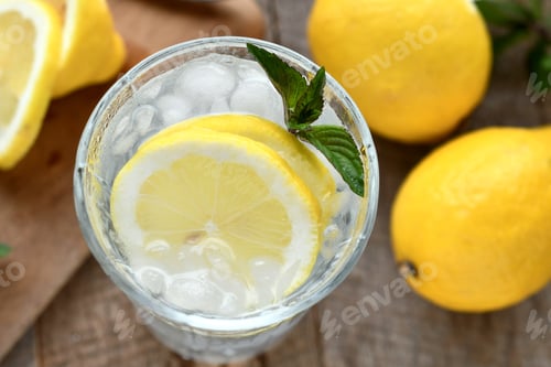 Preview: Glass with sliced lemons, ice and mint containing lemonade or a mixed drink cocktail