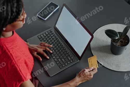 Preview: Woman Using Laptop for Online Banking at Table