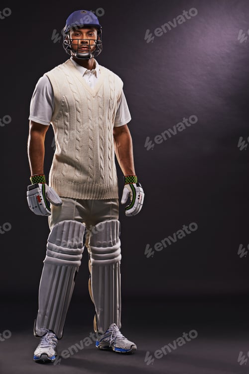 Preview: Ready to hit the pitch. A cropped shot of an ethnic young man in cricket attire isolated on black.