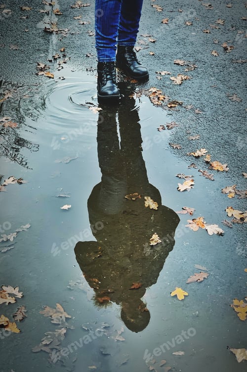 Preview: A reflection of a person in a puddle