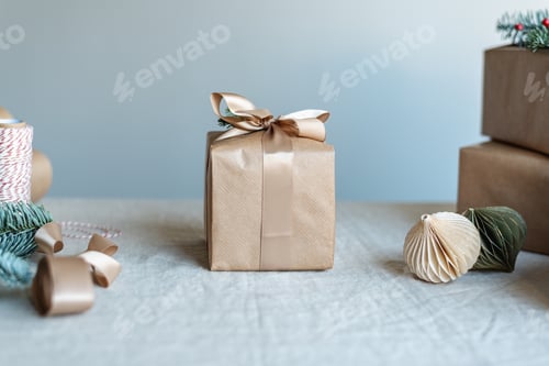 Preview: Beautifully wrapped Christmas present and wrapping decor on the table.