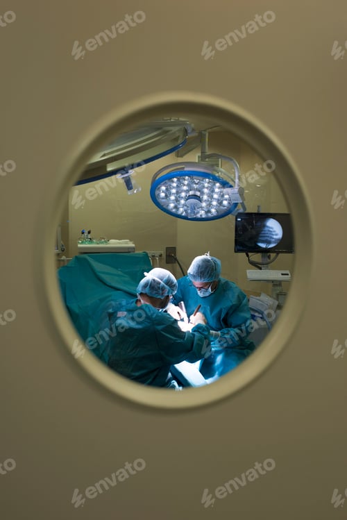 Preview: Surgeons during a surgery behind the door