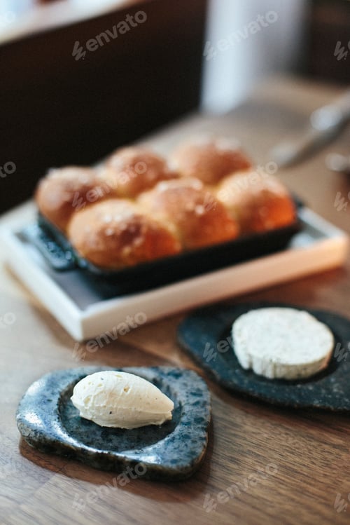 Preview: A tray of freshly baked bread rolls and cheese on a table top at a city restaurant.