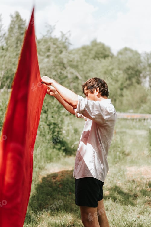 Preview: candid young mature choring man chore homework and hanging the laundry to dry on a clothesline on th
