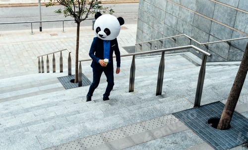 Preview: Storytelling image of a business man wearing a giant panda head