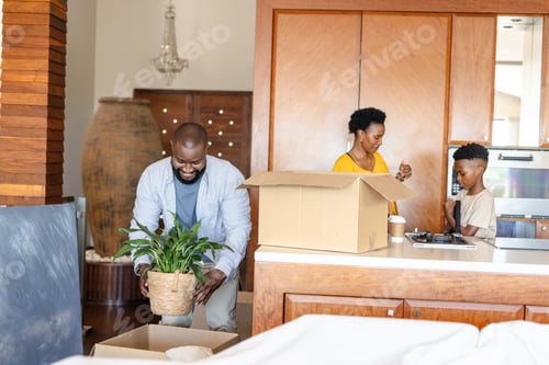 Preview: Family unpacking boxes at home, smiling and organizing new living space