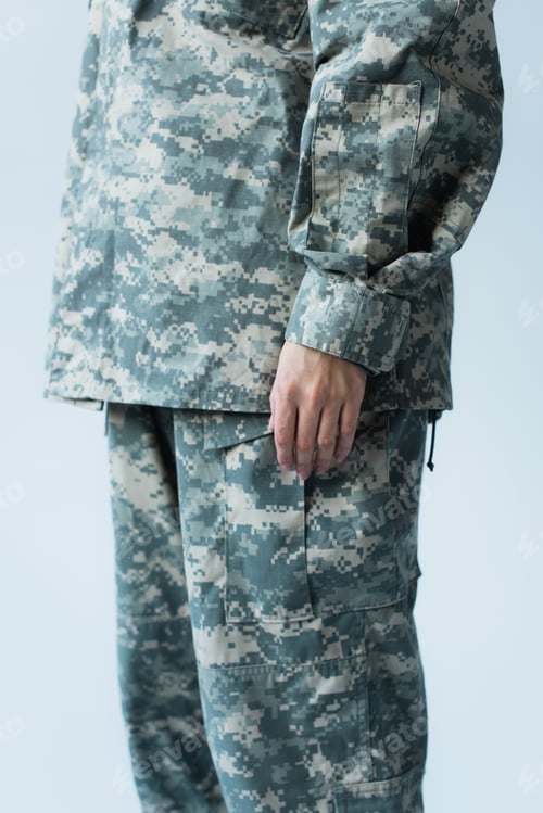 Preview: Cropped view of servicewoman in camouflage uniform standing isolated on grey