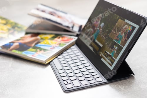 Preview: technology, age, memories and people concept. photobook album and tablet on the table