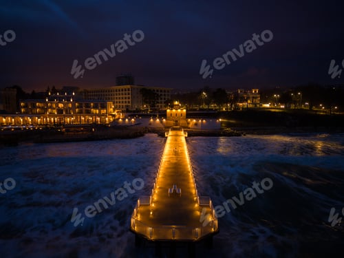 Preview: illuminated pier with dramatic sky over stormy dark sea at evening, Varna Bulgaria