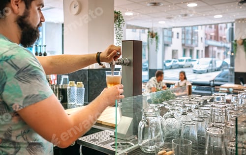 Preview: Bartender pouring beer from tap with customers sitting on background of restaurant