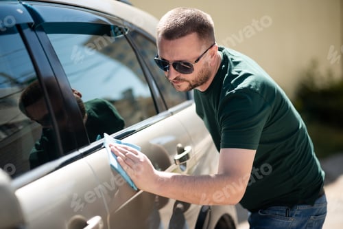 Preview: man washing a car with a sponge