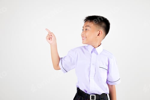 Preview: Portrait smile Asian little boy primary posing point finger to side away studio isolated white