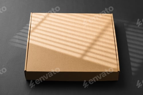 Preview: A cardboard box casting shadows on a dark surface in a striped light pattern
