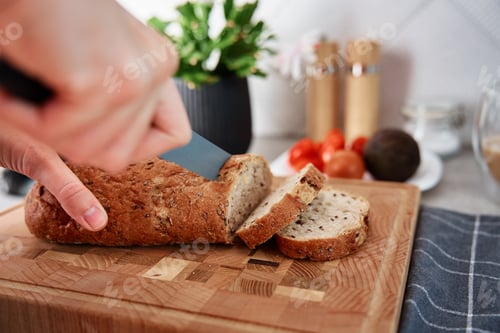 Preview: Woman Cutting Loaf Of Bread With Large Knife