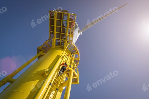 Preview: Engineer climbing wind turbine from boat at offshore windfarm, low angle view