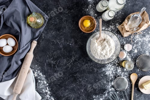 Preview: top view of arranged kitchenware and ingredients for bread baking on dark marble surface
