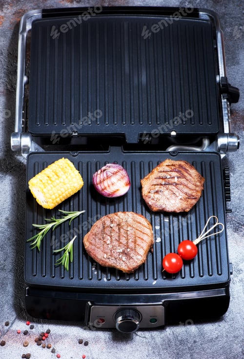 Preview: Preparation beef steaks and vegetables on an electric grill