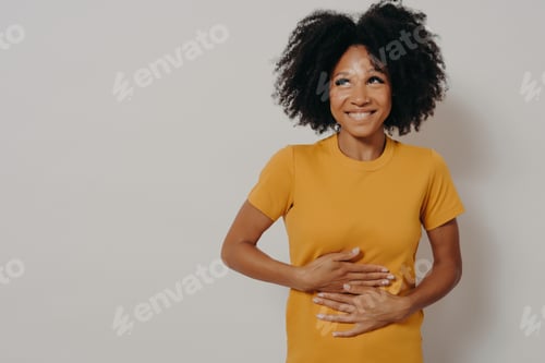 Preview: Happy african american woman laughing out loud at some hilarious joke, keeping hands on stomach