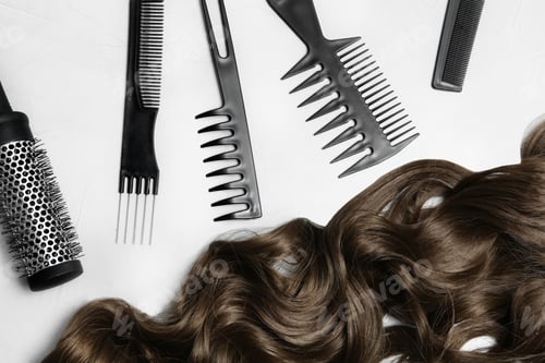 Preview: Flat lay composition with brown hair and hairdresser's tools on light background