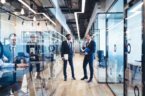 Preview: Multiethnic partners having conversation in office corridor