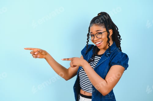 Preview: Check this offer. Positive black lady pointing fingers at free space looking and smiling