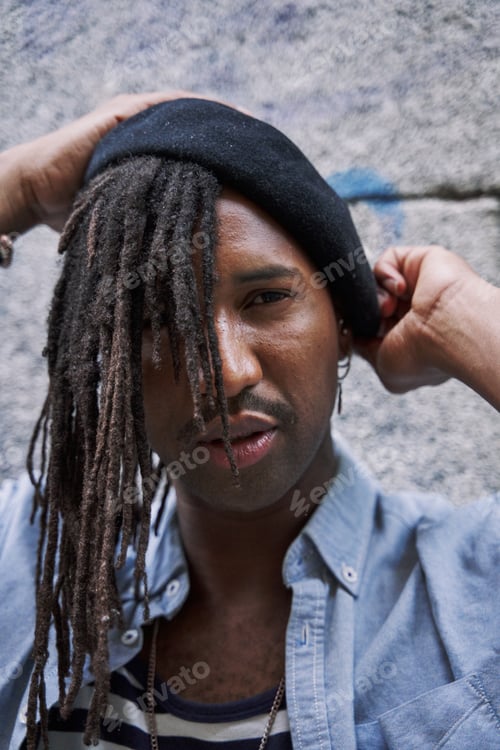 Preview: Serious African American male with dreadlocks and eyeglasses while looking away