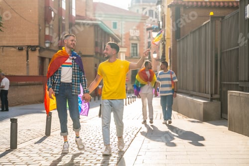 Preview: Gay pride party in the city, male couples walking to the demonstration with the rainbow flags