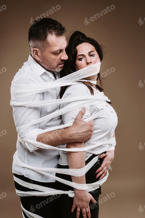 Preview: An aggressive man embraces a battered woman and is wrapped in bandages together. Domestic violence