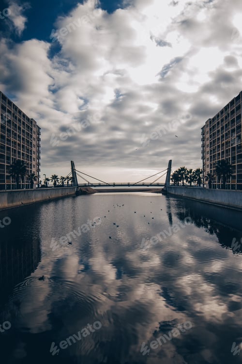 Preview: Water†canal between building and cloudy sky